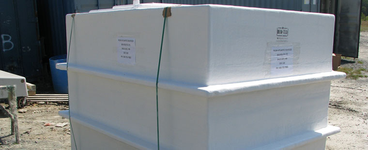 White fiberglass rectangular tank with Dura-Tech labeling at outdoor manufacturing facility