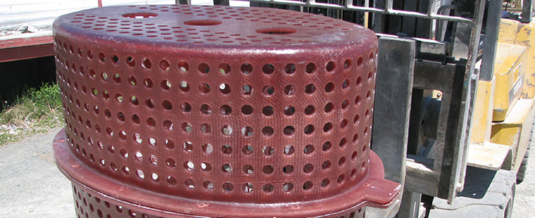 Dura-Tech custom fiberglass cylindrical tank with perforated sides being moved by forklift