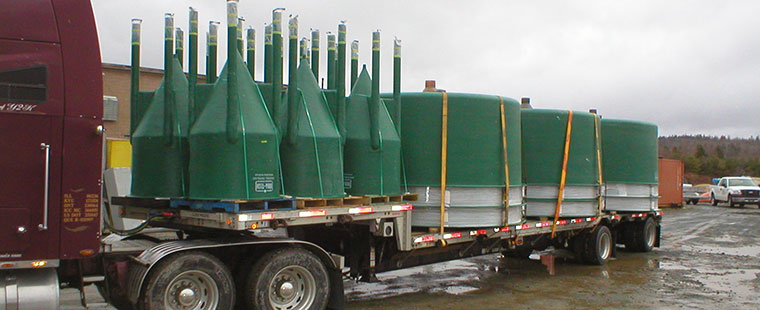 Dura-Tech fiberglass conical bottom tanks loaded on flatbed truck for delivery to aquaculture facility