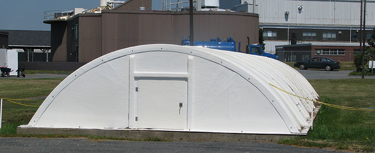 White fiberglass domed cover with access doors at industrial facility