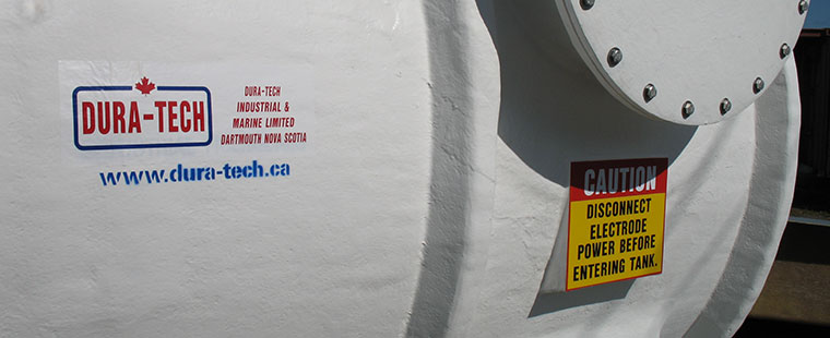 Dura-Tech fiberglass horizontal saddle tank with company logo and electrical safety warning label