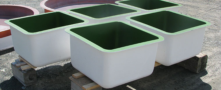 Dura-Tech fiberglass rectangular aquaculture tanks with green interior coating on wooden pallets