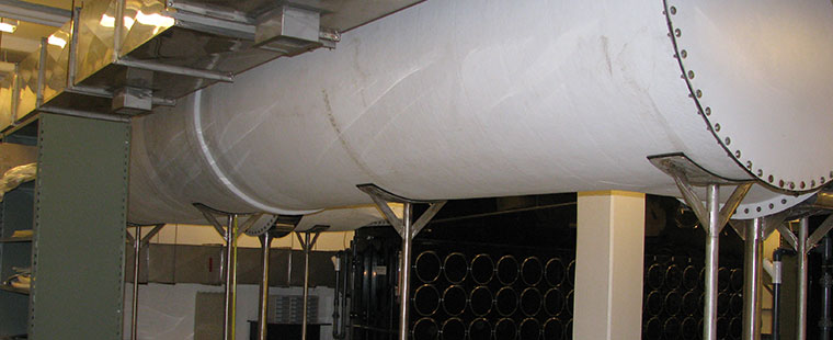 Large white fiberglass ventilation duct system installed in industrial facility ceiling