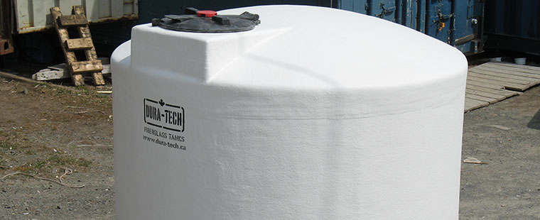Dura-Tech white fiberglass vertical storage tank with top access port at manufacturing facility