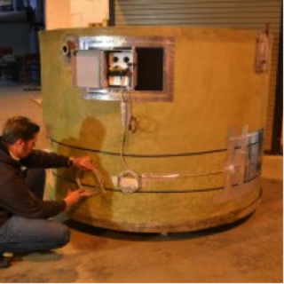 Technician installing heating system on large fiberglass aquaculture tank at Dura-Tech facility